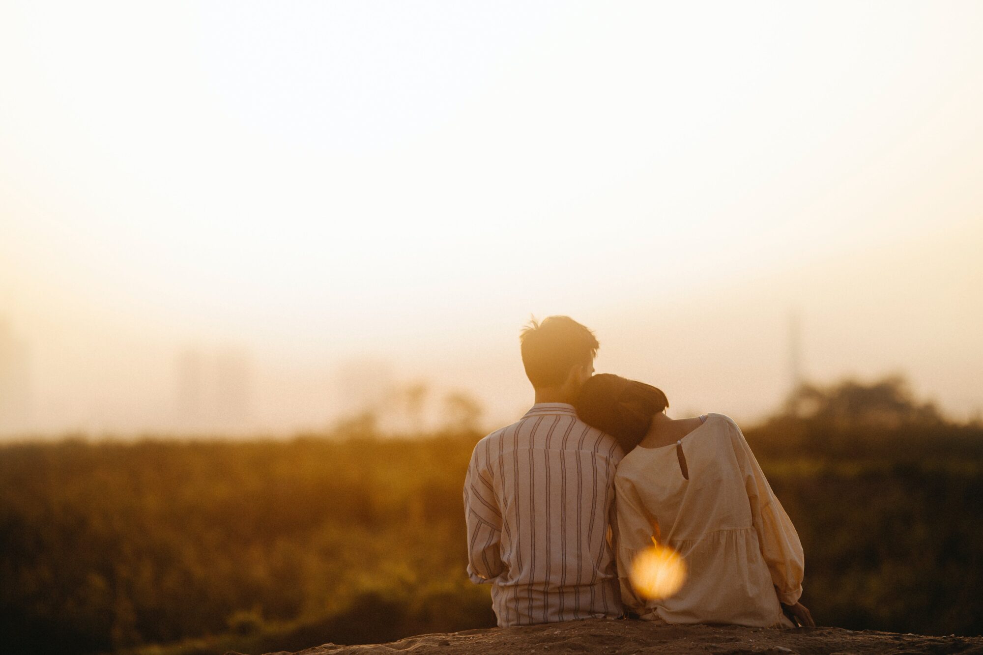 Image d'un couple amoureux assis admirant le soleil.