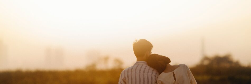 Image d'un couple amoureux assis admirant le soleil.